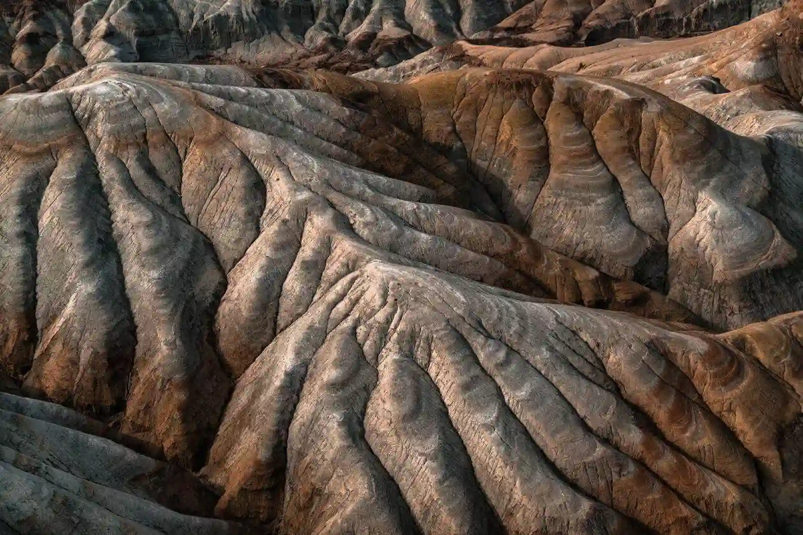 Aerial close-up of the ribbed grey and brown clay slopes of the Aktau Mountains